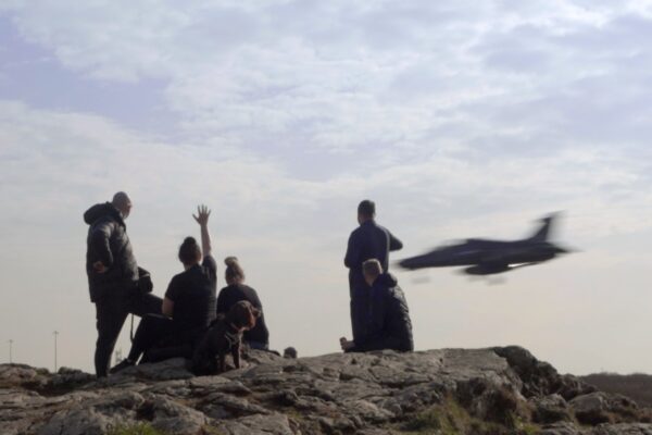 Locals watch the latest low-flying jet pass over