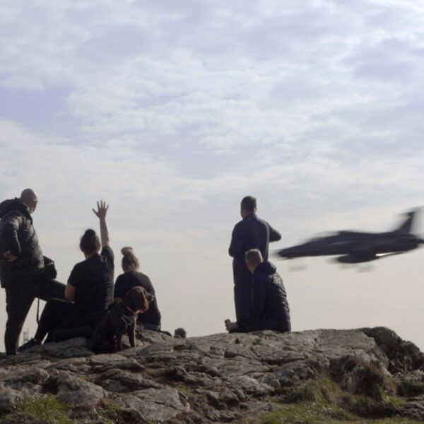 Locals watch the latest low-flying jet pass over
